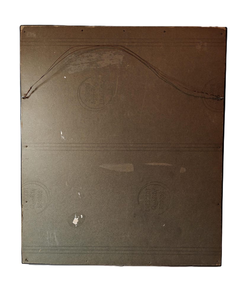 May include: The back of a framed picture with a brown wooden frame. The back of the frame is made of a light brown cardboard material. There are three circular stamps on the back of the frame. The stamps are all in black and white and have text that is difficult to read.