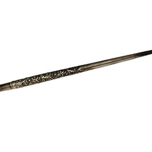 May include: A silver-colored metal pen with an ornate design. The pen is about 15 cm long and has a pointed tip.