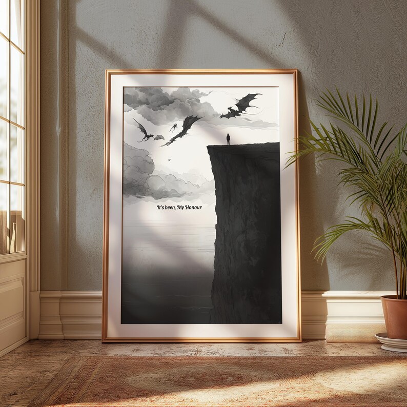 Op de afbeelding: Een ingelijste zwart-wit kunstprint met een illustratie van draken die over een klif vliegen. Een eenzaam figuur staat op de rand, met de tekst "It's been, My Honour" eronder. De print is gepresenteerd in een goudkleurige lijst.