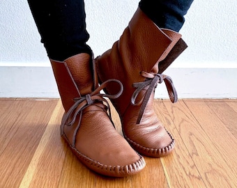 May include: A pair of brown leather ankle boots with laces. The boots have a pointed toe and a low heel.