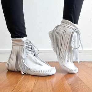 handmade moccasins | indigenous maker | fringe moccassins | fringe boot | hi-top moccasins | moccasin boots | white leather | barefoot shoes
