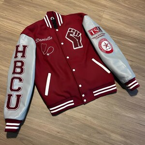 May include: Maroon and gray letterman jacket with white accents. Features the letters "HBCU" on the left sleeve and a raised fist graphic. Includes the name "Danielle" and a stethoscope. The right sleeve displays "TSU Texas Southern University".
