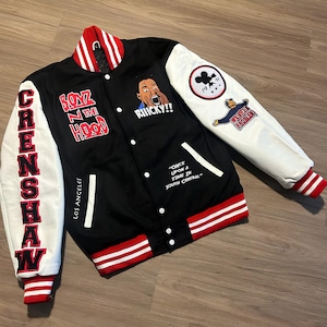 May include: Black varsity jacket with white sleeves, red and white striped trim, and multiple patches. The jacket features the text "CRENSHAW" down the left sleeve and "BOYZ N THE HOOD" on the chest. Additional text includes "RIIICKY!!" and "LOS ANGELES."
