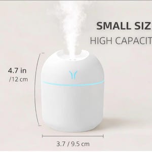 Peut inclure: Un humidificateur blanc de petite taille et de grande capacité. Il émet de la vapeur et possède une lumière bleue. L'humidificateur mesure 12 cm de haut et 9,5 cm de large. Le texte sur l'image indique "SMALL SIZE HIGH CAPACITY".