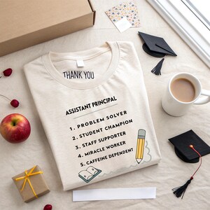 May include: A beige t-shirt with the text "THANK YOU" and "ASSISTANT PRINCIPAL" printed on it. The text is followed by a list of five job duties, including "PROBLEM SOLVER", "STUDENT CHAMPION", "STAFF SUPPORTER", "MIRACLE WORKER", and "CAFFEINE DEPENDENT". A yellow pencil is drawn next to the list.
