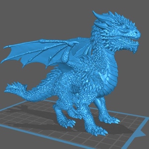 Può includere: Una statuetta di drago blu stampata in 3D con squame, ali e una lunga coda dettagliate. Il drago è posizionato su una superficie a griglia, che mostra il suo design e la sua consistenza intricati. Un oggetto da collezione a tema fantasy.