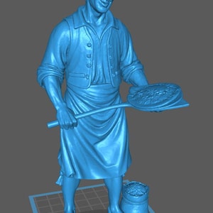 Könnte beinhalten: Blaue Statue eines Bäckers, der eine Pizzaschaufel mit einem Brot hält. Der Bäcker trägt ein Hemd, eine Weste und eine Schürze. Ein Sack Mehl und ein Brot liegen zu seinen Füßen. Die Statue steht auf einer karierten Oberfläche.