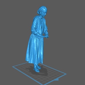 Può includere: Rendering 3D di una persona con un abito lungo e scarpe, con le mani giunte davanti a sé. La figura è azzurra e si trova su una superficie a motivi. Lo sfondo è grigio.