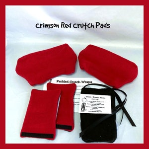 May include: Crimson red padded crutch wraps with black velcro straps. The set includes two large wraps and two smaller wraps. A black pouch with a white label that reads "Crutch 'Crutch' Purse My Cap" is also included.