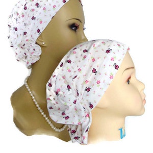 Peut inclure: Deux couvre-chefs blancs avec un imprimé de coccinelle rose et noire. Les couvre-chefs sont faits d'un tissu doux et extensible et sont conçus pour être confortables et élégants.