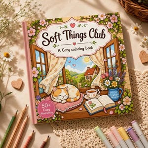 Peut inclure: Un livre de coloriage intitul&eacute; "Soft Things Club" avec une illustration chaleureuse d'un chat dormant pr&egrave;s d'une fen&ecirc;tre. La couverture pr&eacute;sente des motifs floraux et le texte "A Cozy coloring book" et "50+ Cozy illustrations". Des crayons de couleur et des marqueurs sont dispos&eacute;s autour du livre.