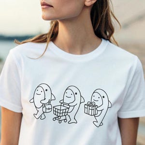 Playful Shark Shopping Tee, Blahaj , Fun Graphic T-Shirt, Cute Unisex Top, Gift for Ocean Lovers, Casual Wear, Quirky Gift Idea