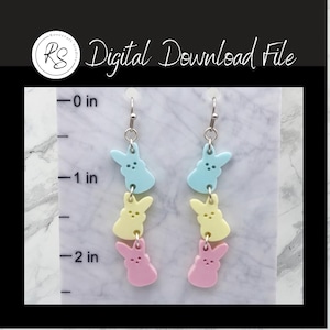 May include: A pair of dangling earrings featuring a pastel color scheme. Each earring has three bunny-shaped charms in blue, yellow, and pink. The text "Digital Download File" is visible in the image.