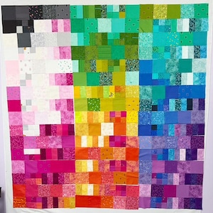 May include: A colourful quilt made of small squares of fabric in various shades of pink, green, blue, yellow, orange, and purple. The quilt is arranged in a grid pattern, with each square being a different colour.