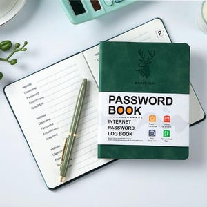 以下が含まれることがあります： 「PASSWORD BOOK」と「INTERNET PASSWORD LOG BOOK」の文字が入った緑色のパスワード帳。鹿のロゴが入っています。ウェブサイトやパスワードのフィールドがある、開いたノートとペンも写っています。