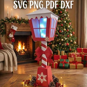 May include: A red and white Christmas lantern with the text "SVG PNG PDF DXF". The lantern has a snowflake design and a red bow. It is decorated with pinecones, berries, and fairy lights. A Christmas tree and fireplace are in the background.