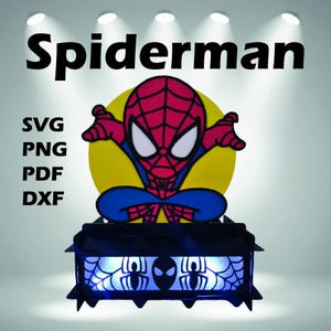 Könnte beinhalten: Ein Spiderman-Nachtlicht mit einer rot, blau und weiß gehaltenen Spiderman-Figur vor einem gelben Kreis. Der schwarze Sockel hat Spinnennetz- und Spinnenmuster, die von blauen Lichtern beleuchtet werden. Das Wort "Spiderman" steht oben.