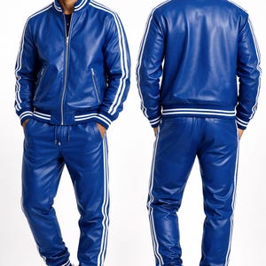 Puede incluir: Un ch&aacute;ndal de cuero azul con una chaqueta con cremallera y pantalones a juego, ambos con rayas blancas. La chaqueta tiene cuello y pu&ntilde;os de canal&eacute;. El modelo lleva zapatillas blancas.