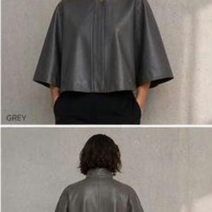 May include: A grey leather cape with a high collar and button closure. The cape has a wide, flowing silhouette and short sleeves. The word "GREY" is printed in the lower left corner of the image.