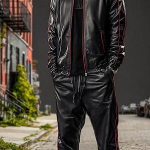 May include: A person wearing a black leather jacket with red trim, a black t-shirt, and black leather pants with red trim. The person is also wearing black and white sneakers. The outfit is a modern take on streetwear.