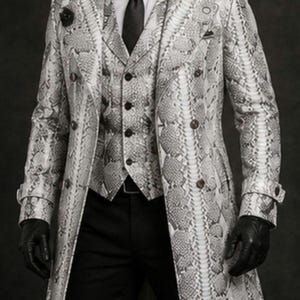 May include: A three-piece suit featuring a snakeskin pattern in shades of gray and white. The suit includes a long trench coat, a vest, and a matching tie. The outfit is completed with black gloves and pants. The text "TRENCH COAT" is visible.
