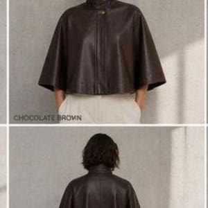May include: A chocolate brown leather cape with a high collar and button closure. The cape has a wide, flowing silhouette and is shown from the front and back. The text "CHOCOLATE BROWN" is at the bottom of the image.