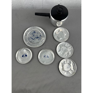 May include: A set of three ceramic mugs with a speckled, matte finish. Each mug features a different color: light blue, cream, and gray. The mugs have a simple, modern design with a rounded shape and a comfortable handle.