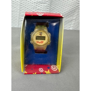 May include: A vintage Disney Fest digital watch in its original box. The watch has a clear, yellowed plastic case and band. The watch face features Mickey Mouse and the text "Disney Fest". The box is red, yellow, and blue.