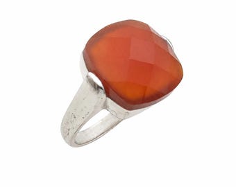 May include: A silver ring featuring a large, square-shaped, faceted orange gemstone. The stone has a cushion-cut profile with multiple triangular facets that catch the light, set securely into a polished silver band with a smooth, rounded finish.