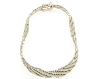 May include: A silver-toned bracelet featuring a woven, multi-strand design with a textured, beaded appearance. The bracelet is constructed from several parallel, twisted metal strands and includes a rectangular box clasp closure at the top.