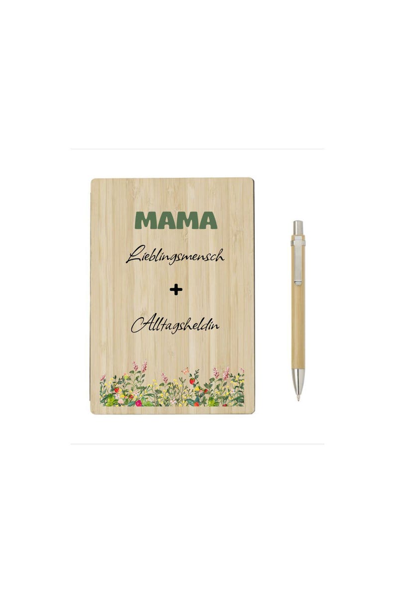 May include: A wooden plaque with the word "MAMA" in green, followed by text in cursive. The plaque has a floral border at the bottom. A pen with a silver tip and a light brown barrel is to the right.