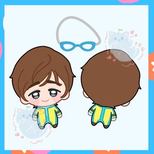 May include: A cartoon illustration of a swimmer doll with brown hair, wearing a yellow and blue swimsuit. The doll has blue goggles and a white swim cap. The image shows the front and back of the doll.