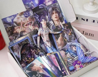 Peut inclure: Une boîte blanche remplie de produits dérivés sur le thème de la fantaisie. La boîte contient divers articles, notamment des tirages d'art, des cartes à collectionner et une petite figurine. Les tirages et les cartes présentent des illustrations de personnages masculins aux cheveux longs et en tenue fantastique.
