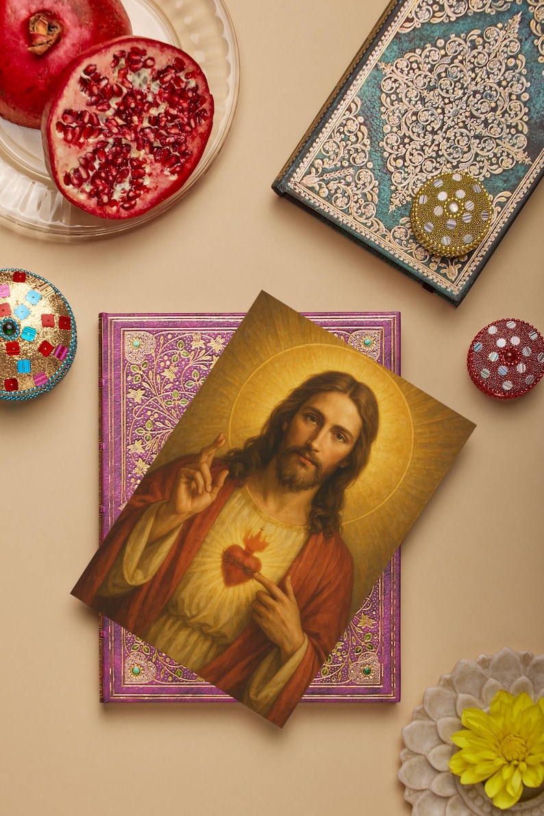 May include: An image featuring a portrait of Jesus Christ, a purple journal, and a teal journal with ornate designs. Also included are decorative round containers, a pomegranate, and a flower.