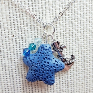 May include: A silver chain necklace with a blue lava rock starfish charm, a silver anchor charm, and blue crystal beads.