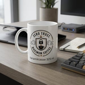 May include: A white ceramic mug featuring a circular graphic with a central shield icon containing a padlock and a coffee cup. The text reads Zero Trust, Maximum Coffee, Verify Everything, and Trust Nothing. The base text reads Keramiktasse 325 ml.