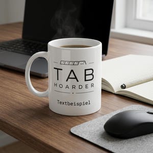 Könnte beinhalten: Ein weißer Keramikbecher mit einem schwarzen Grafikdesign, das den Text TAB HOARDER und ein kleines Tastatur-Tab-Symbol darüber zeigt. Unter dem Haupttext sind die Wörter Textbeispiel in einer einfachen schwarzen serifenlosen Schrift aufgedruckt.