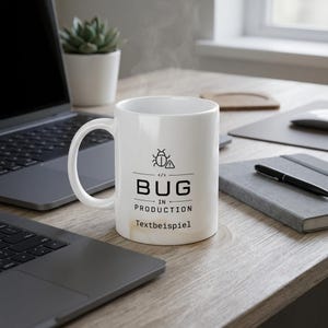 Könnte beinhalten: Ein weißer Keramikbecher mit einer schwarzen Grafik eines Käfer-Symbols mit einem Warndreieck, dem Text "BUG IN PRODUCTION" mit Code-Klammern und dem Wort "Textbeispiel", das in Schwarz auf der Vorderseite des Bechers aufgedruckt ist.