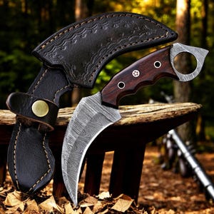 Pu&ograve; includere: Un coltello karambit curvo con una lama a motivi e un manico in legno scuro. Il coltello &egrave; abbinato a un fodero in pelle nera. L'impugnatura presenta elementi metallici decorativi. La lama ha un motivo ondulato unico.