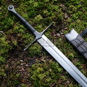 May include: A steel sword with a long, double-edged blade, a black grip, and a circular pommel. The crossguard is straight and thin. A matching scabbard with a silver-colored metal throat and black leather body lies beside the sword blade.