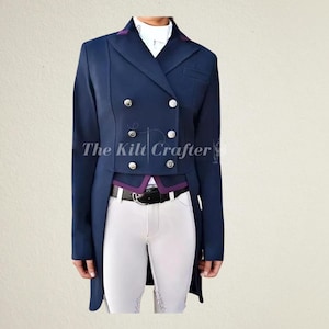 May include: A navy blue equestrian jacket with a double-breasted design and silver buttons. The jacket has a purple collar and trim, and is paired with white riding pants and a black belt. The text "The Kilt Crafter" is visible.