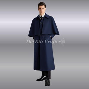 Könnte beinhalten: Ein marineblauer Wollmantel mit Umhang, passender Weste und langem Mantel. Der Mantel hat einen Gürtel und Taschen. Der Text "The Kilt Crafter" ist sichtbar. Getragen mit schwarzer Hose und Schuhen.