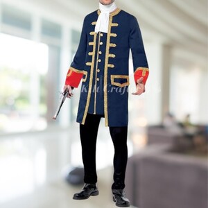 May include: A navy blue costume coat with gold trim, red cuffs, and gold buttons. The coat has a long, tailored design, and is paired with black pants and shoes. A white cravat is worn at the neck. A silver pistol is held in the hand.