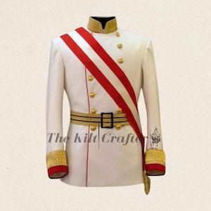 May include: A white military-style jacket with gold buttons, a red sash, and a gold and black belt. The jacket has gold trim on the collar and cuffs. The text "The Kilt Crafter" is visible on the front.
