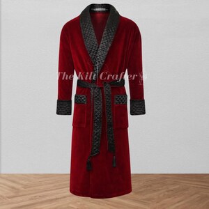 May include: A burgundy velvet robe with black satin trim and a matching belt. The robe features a shawl collar, cuffs, pockets, and a belt with tassels. The text "The Kilt Crafter" is visible on the robe.