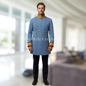 Puede incluir: Un abrigo azul claro de estilo militar con botones dorados, cuello dorado y puños rojos. El abrigo se combina con pantalones azul marino oscuro y zapatos negros. El logotipo de The Kilt Crafters es visible.