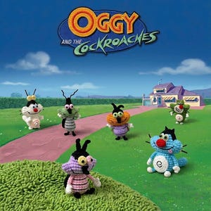 May include: A collection of six small, handcrafted crochet figures inspired by the characters from Oggy and the Cockroaches, featuring various colors including blue, purple, green, and white, arranged on a green surface with a house in the background.