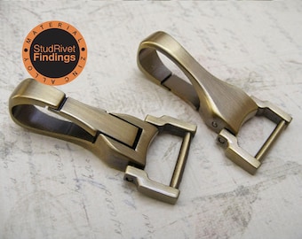 May include: Two antique gold metal swivel clasps. The clasps are made of zinc alloy. The clasps are about 2 inches long.
