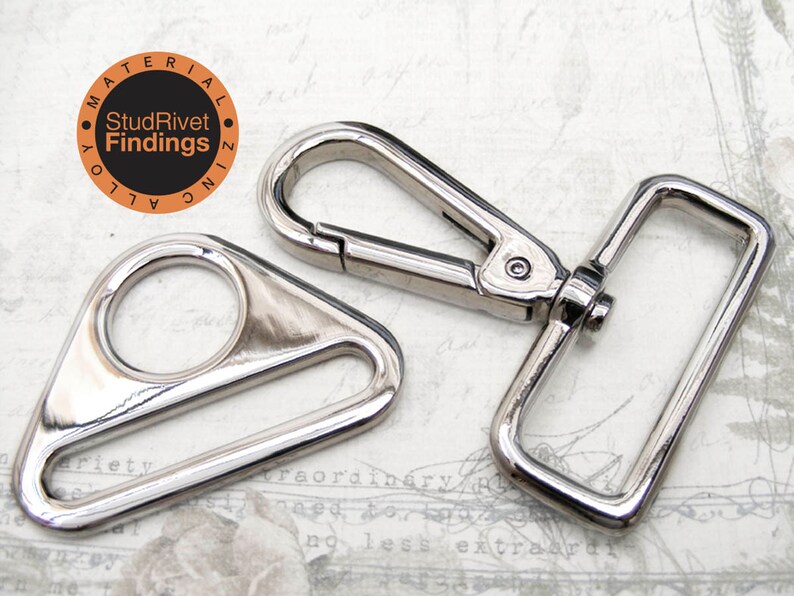 May include: Two silver metal hardware pieces for attaching straps or other accessories. The first piece is a triangular shaped D-ring with a round opening. The second piece is a rectangular swivel hook with a spring-loaded clasp.