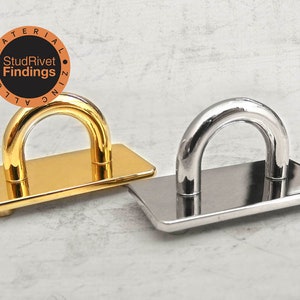 May include: Two metal D-rings, one gold and one silver, with a flat base. The D-rings are made of zinc alloy.